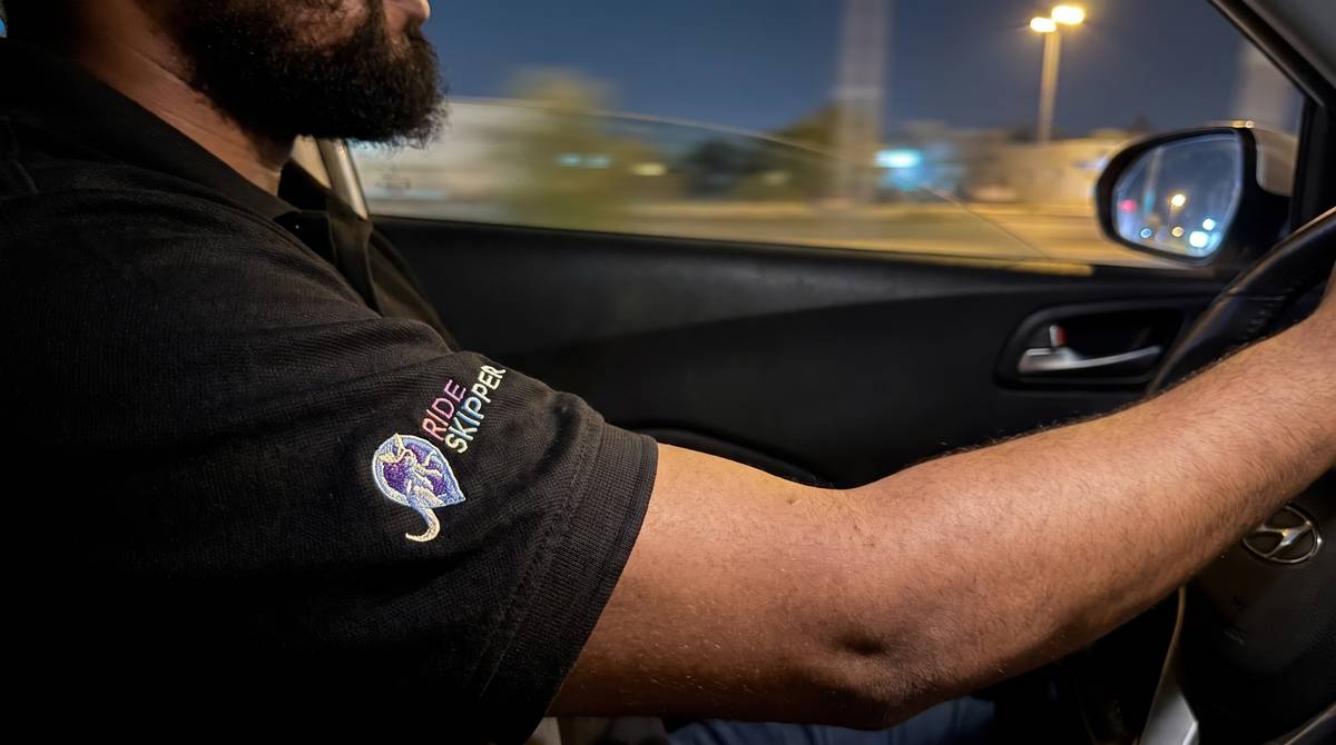 A Skipper at the wheel at night, streetlights passing
