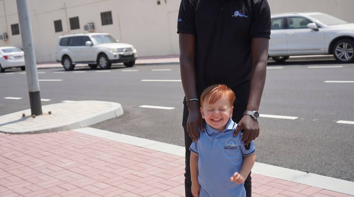 A Skipper with a schoolboy in uniform at the kerbside