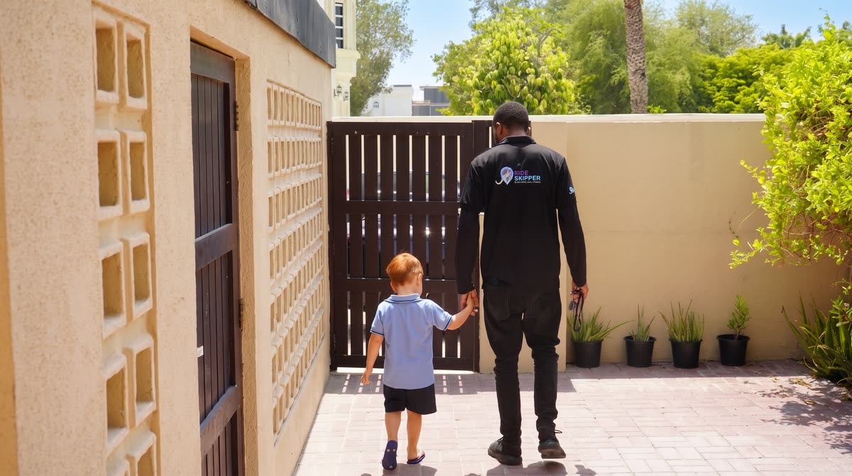 A Skipper walking a schoolboy to the school gate